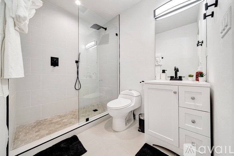 A white bathroom with a toilet, sink, and mirror.