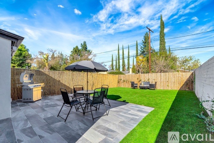 A patio with a table and chairs is set up on a sunny day.