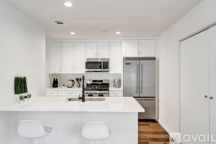 A modern kitchen with white cabinets and appliances.