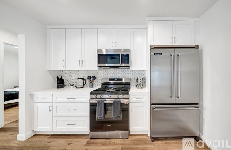 A kitchen with white cabinets and stainless steel appliances.