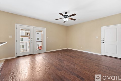A room with a ceiling fan and two doors, one of which is open.