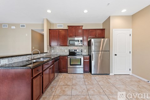 A kitchen with brown cabinets and a black countertop.