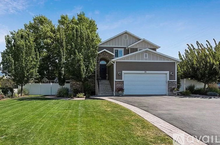 A house with a garage and a driveway in front of it.