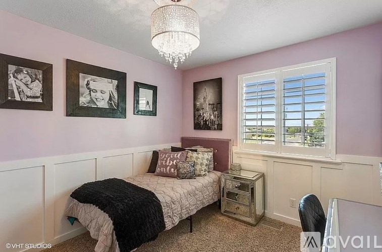 A bedroom with a bed, nightstand, and pictures on the wall.
