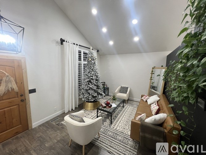 A living room with a Christmas tree and a couch.