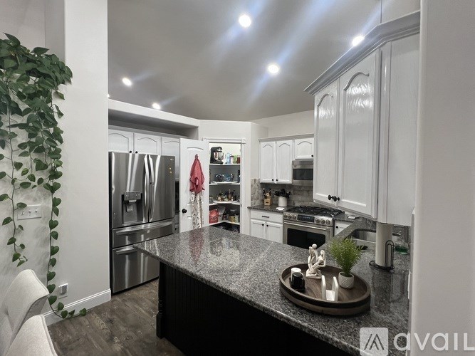 A modern kitchen with a granite countertop and stainless steel appliances.