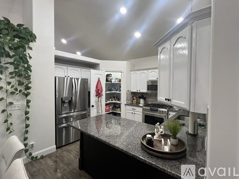 A modern kitchen with a granite countertop and stainless steel appliances.