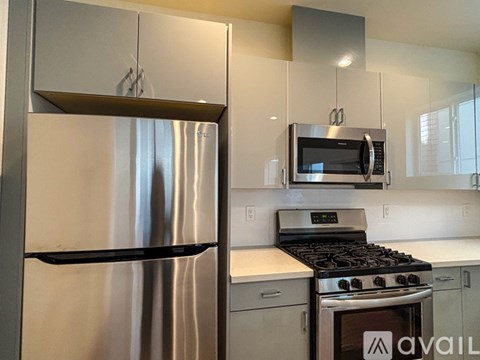 A modern kitchen with a stainless steel refrigerator and a stove with an oven.