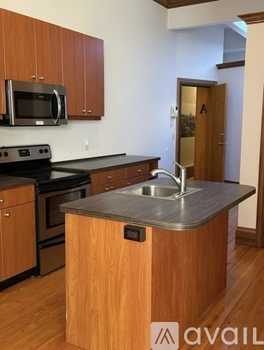 A kitchen with wooden cabinets and a stainless steel sink.