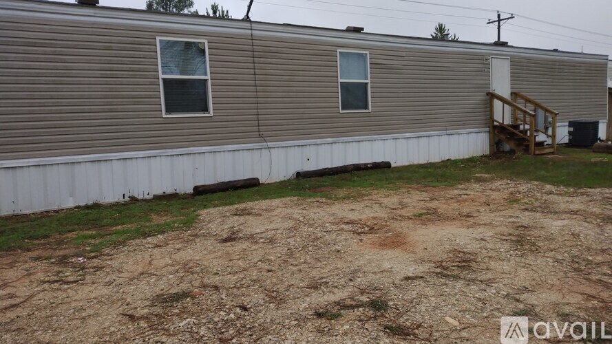 A mobile home with a dirt yard in front.