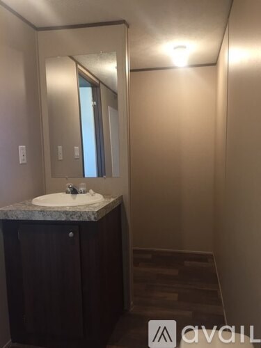 A bathroom with a sink, mirror, and wooden steps.