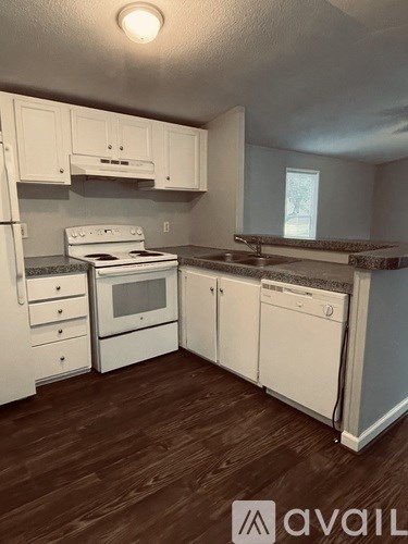A kitchen with white appliances and cabinets.