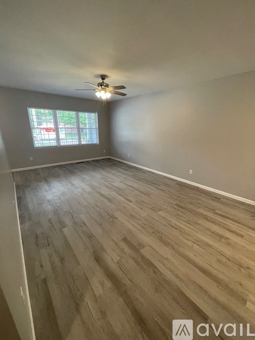 A room with wooden flooring and a ceiling fan.
