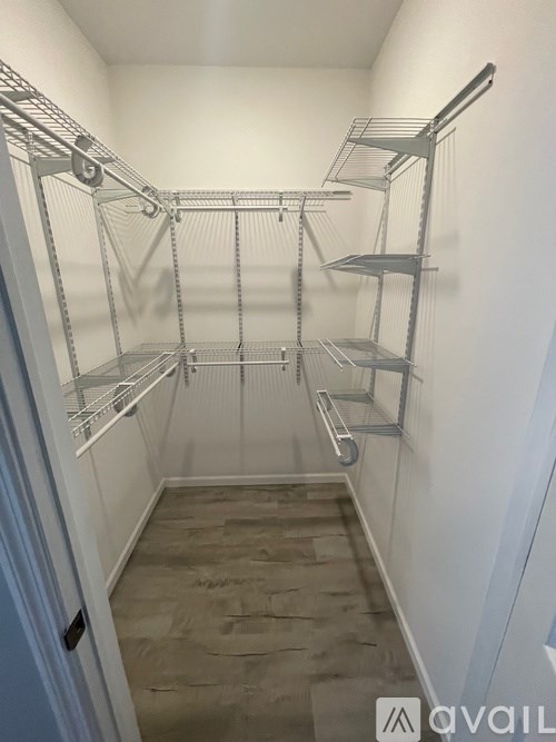 A walk-in closet with shelving and a stone floor.