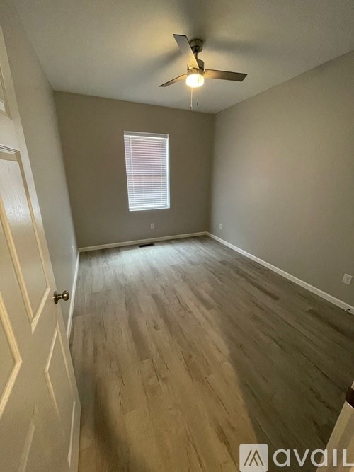A room with a wooden floor and a ceiling fan.