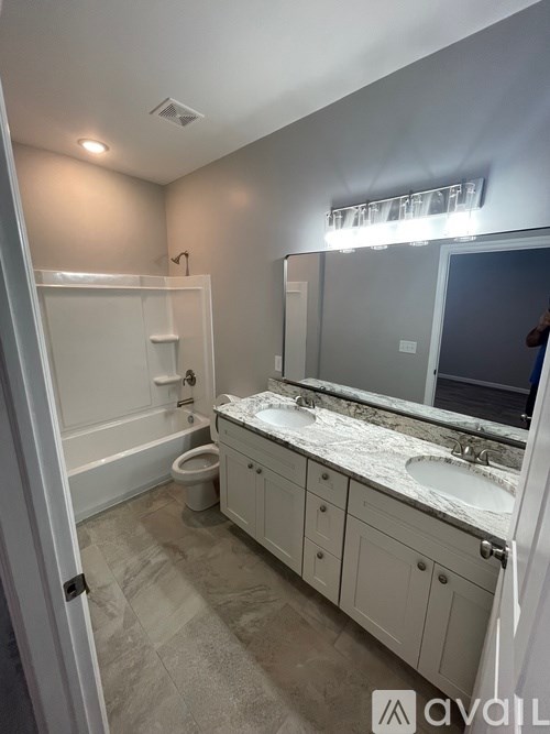 A bathroom with a white vanity and a white toilet.