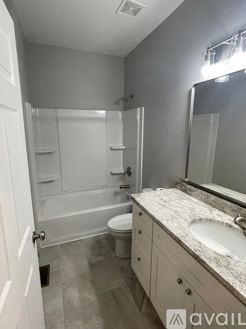 A bathroom with a sink, toilet, and bathtub.