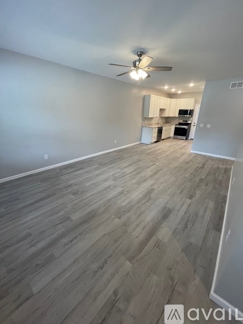 A room with wooden flooring and a ceiling fan.