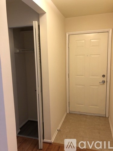 A white door is in a room with a white wall and a white closet door.