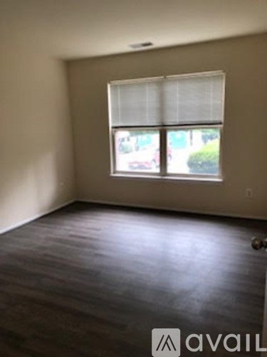 A room with a window and wooden flooring.