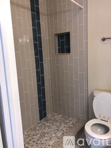 A white toilet in a bathroom with a tiled shower.