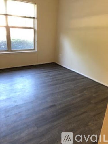 A room with a window and wooden flooring.
