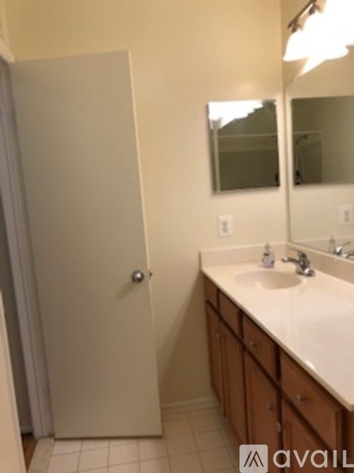 A bathroom with a white sink and a white door.