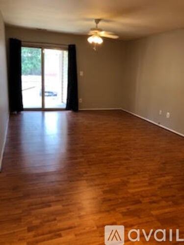 A room with wooden flooring and a ceiling fan.