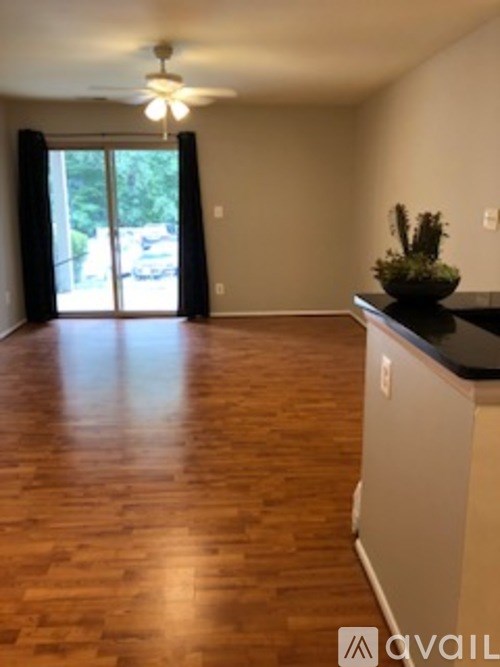 A room with wooden floors and a ceiling fan.