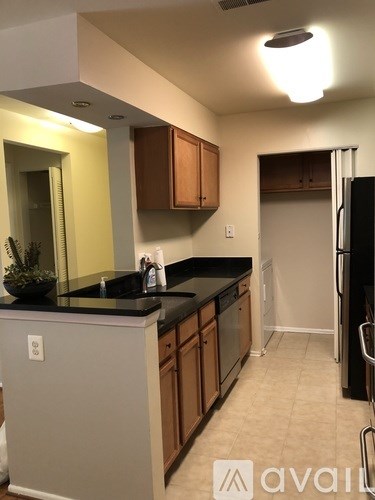 A kitchen with a black counter top and wooden cabinets.