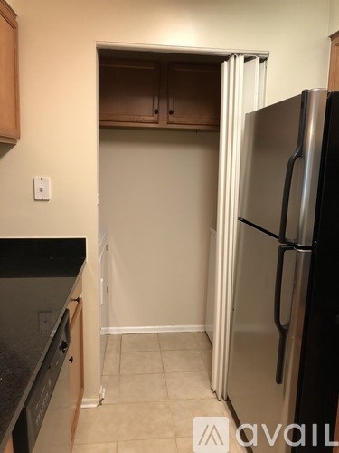 A kitchen with a black counter top and a black fridge.