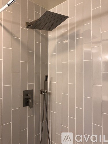 A shower head mounted on a wall in a tiled bathroom.