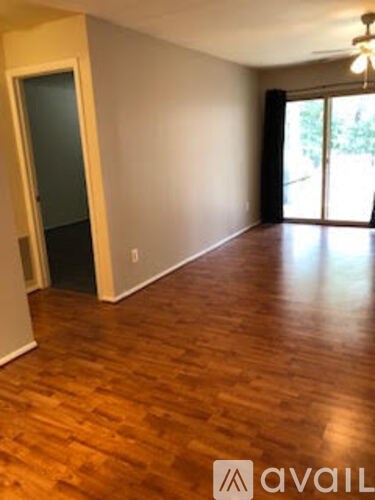 A room with wooden flooring and a sliding glass door.
