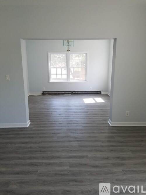 A room with a window and a chandelier.