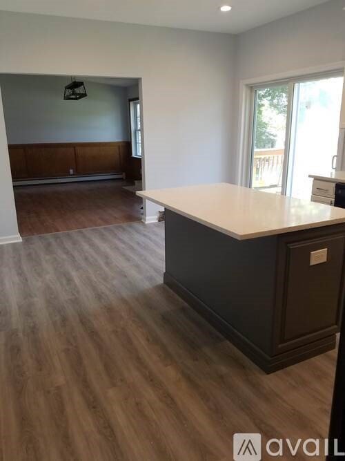 A room with a wooden floor and a large island in the middle.