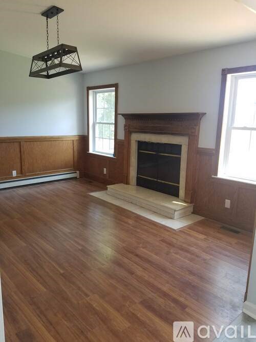 A room with a fireplace and wooden floors.
