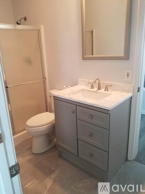 A bathroom with a toilet, sink, and medicine cabinet.