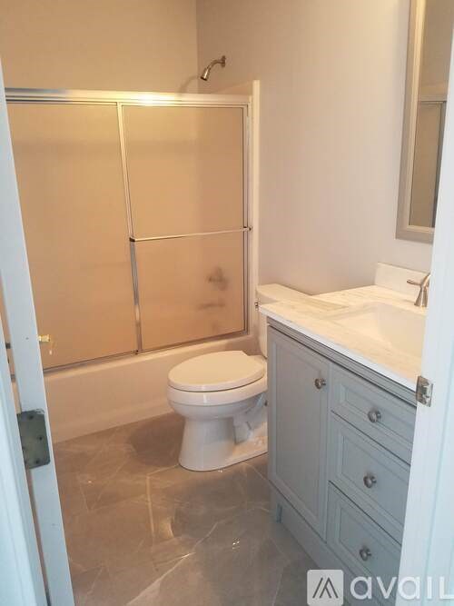 A bathroom with a toilet, sink, and shower.