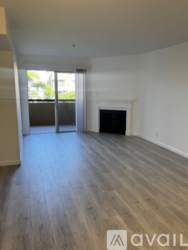 A room with a fireplace and wood flooring.