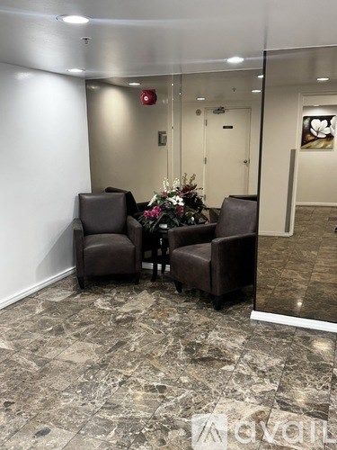 Two brown chairs are placed in front of a glass wall.