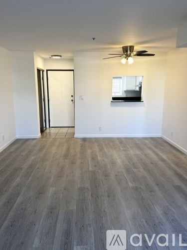 A room with wooden flooring and a ceiling fan.