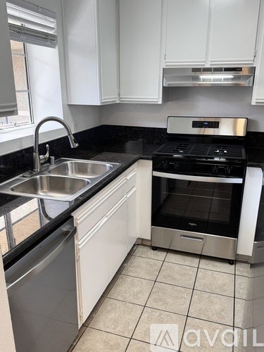 A kitchen with a black counter top and white cabinets.