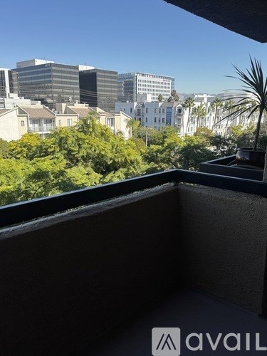 A balcony with a view of a cityscape and palm trees.