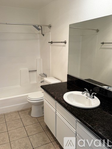 A bathroom with a toilet, sink, and a mirror.