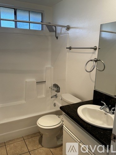 A white toilet sits in a bathroom next to a sink.