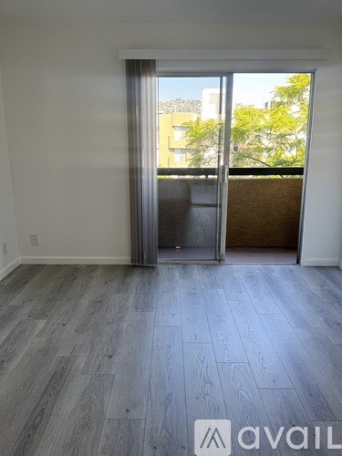 A room with a sliding door leading to a balcony.