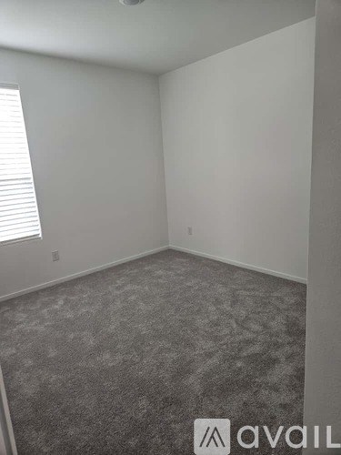 A room with grey carpet and white walls.