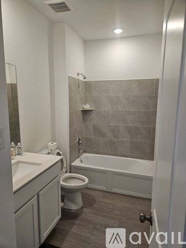 A bathroom with a toilet, sink, and bathtub.