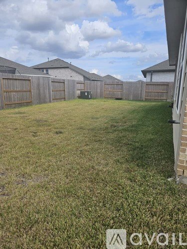 A backyard with a wooden fence and a green lawn.