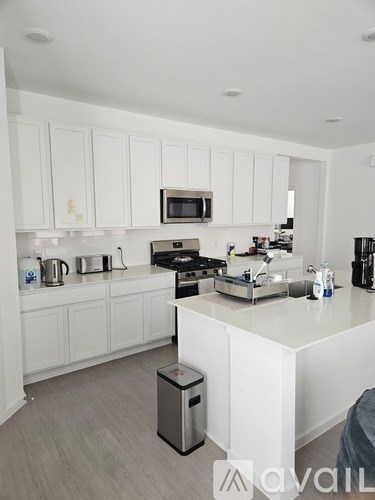 A kitchen with white cabinets and a white counter top.